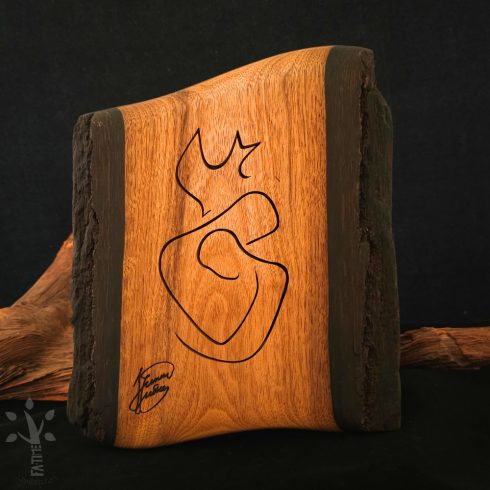 Fa falikép, amely egy stilizált ölelkező párt  ábrázol galmb motívummal a tetején. Precízen kivágott vonalak alkotják a motívumot.