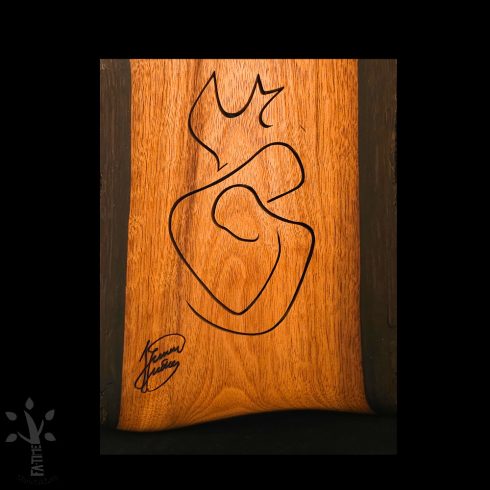 Fa falikép, amely egy stilizált ölelkező párt  ábrázol galmb motívummal a tetején. Precízen kivágott vonalak alkotják a motívumot.