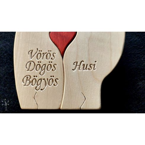 A pair of hugging polar bears made from light-colored wood, holding a red heart in their lap.